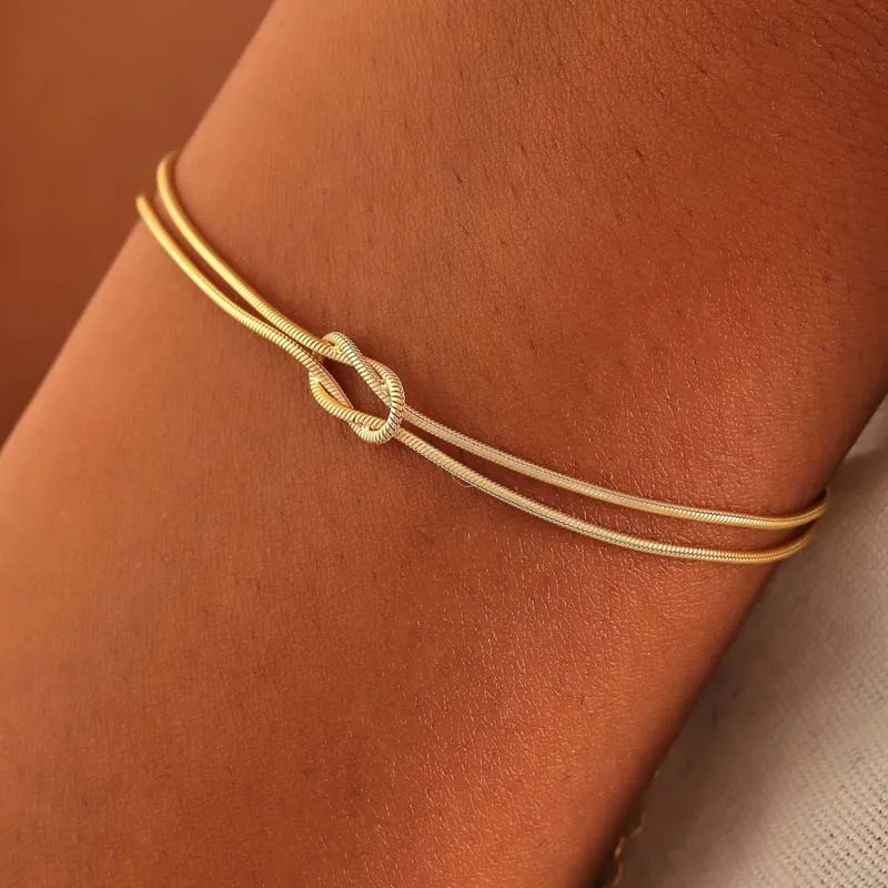 Delicate layered gold bracelets with knot clasp, minimalist jewelry accessory