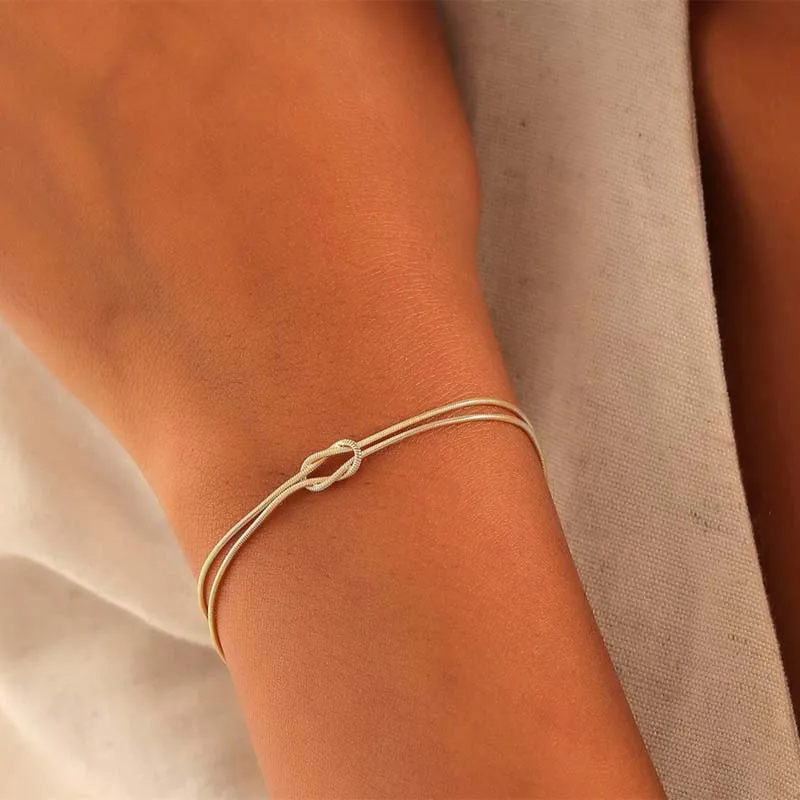 Gleaming gold bracelets with interlocked knot design, modern and chic accessories