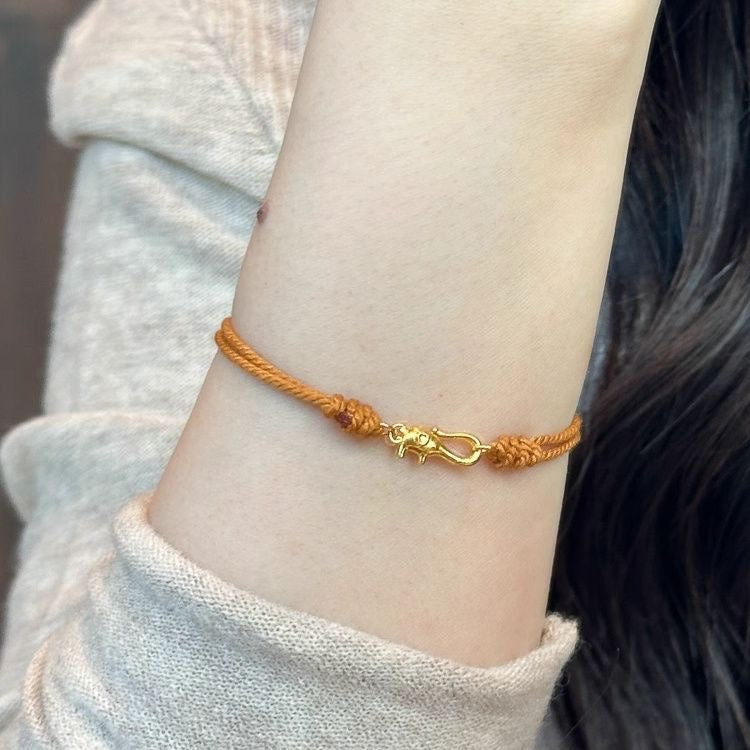 Orange braided gold coil bracelet buckle close-up