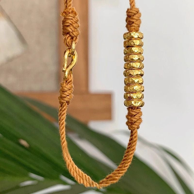 Orange braided gold coil bracelet close-up