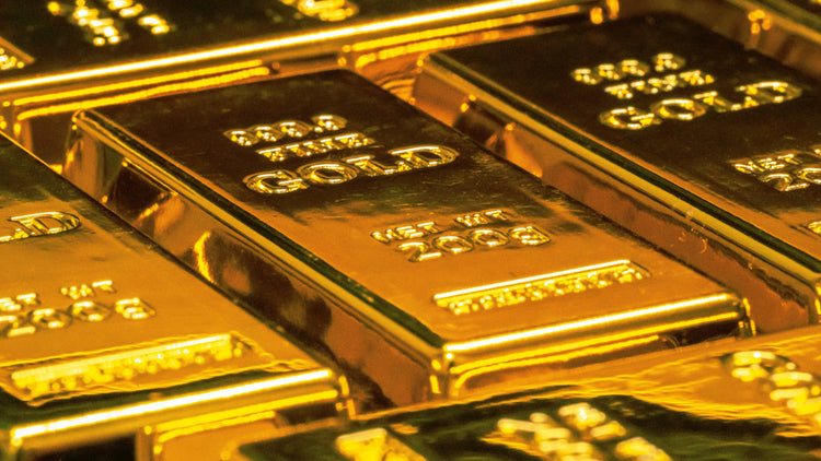 Close-up of gleaming gold bars stacked together, each stamped with '999.9 FINE GOLD,' symbolizing wealth and prosperity