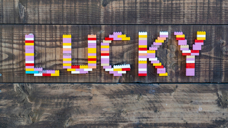 The word 'LUCKY' creatively arranged with colorful building blocks on a rustic wooden background, symbolizing good fortune and playfulness