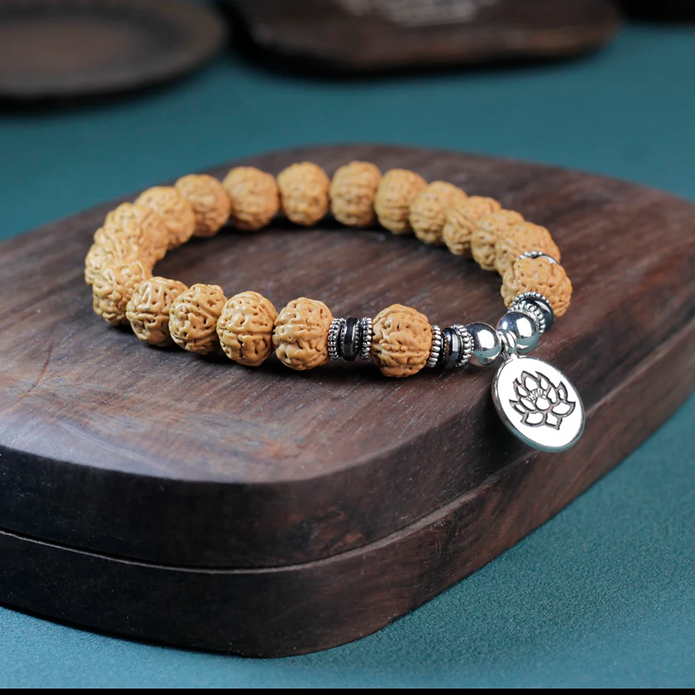 Rudraksha bracelet with unique silver lotus charm, symbolizing purity and enlightenment