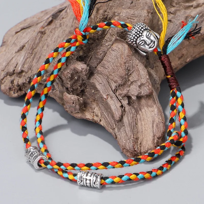 Handcrafted multicolor woven bracelet with a Buddhist-inspired metal charm detail