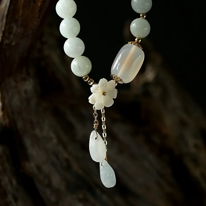 layered white quartz bead bracelets with floral accents, elegantly stacked design