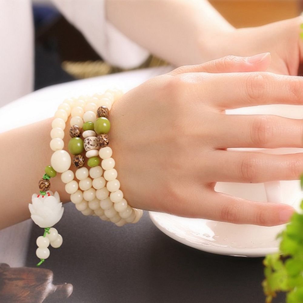 Intricate white and green beaded bracelet adorning a woman's hand