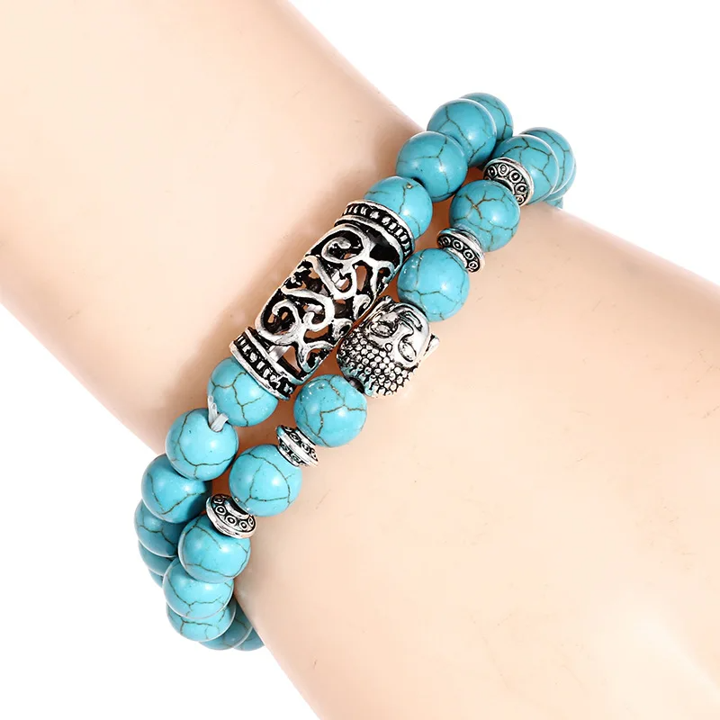  A blue howlite bead bracelet displayed on a wrist, featuring a silver Buddha charm and stylish zinc alloy details