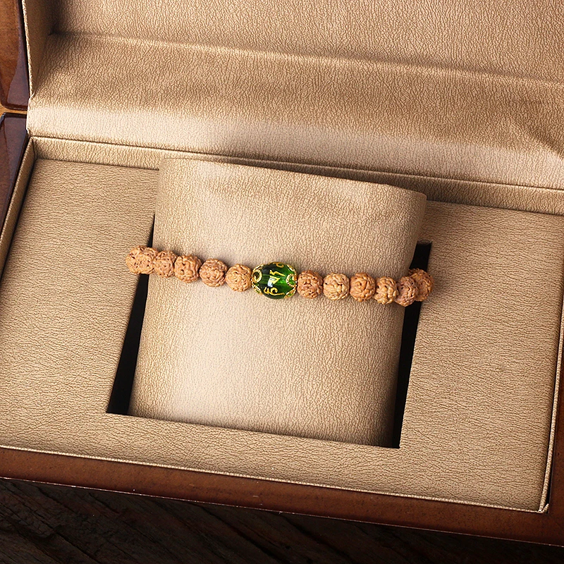 Bracelet with emerald green Rudraksha beads and copper accents, nature-inspired design