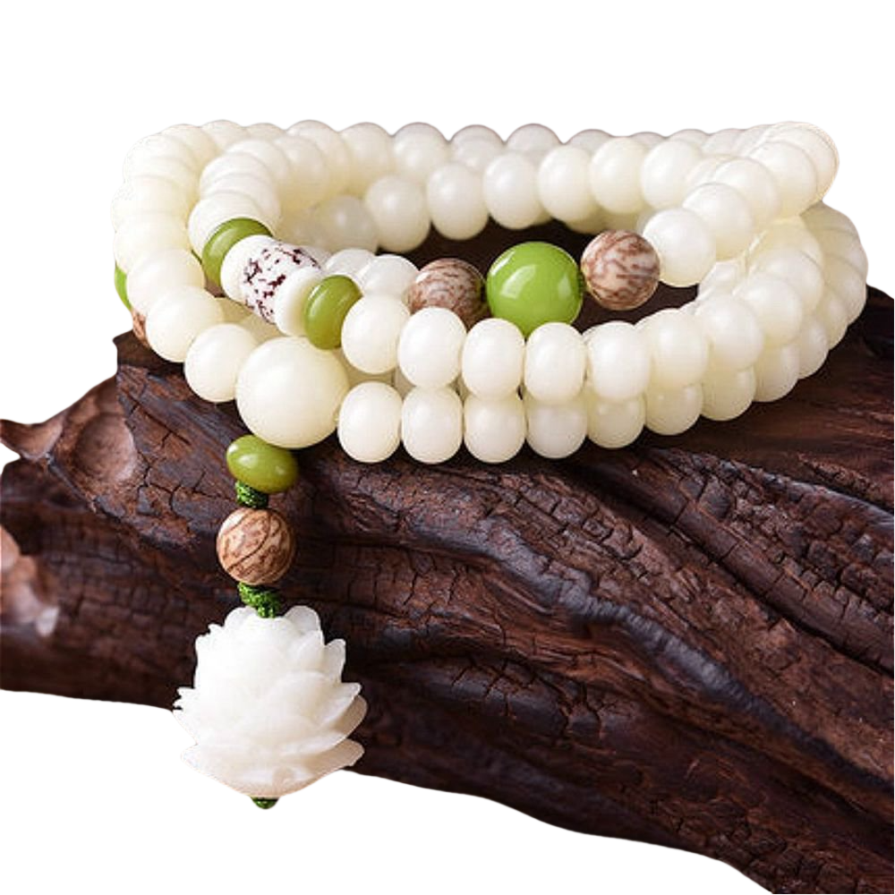 Intricate white beads and green accents on a wooden surface