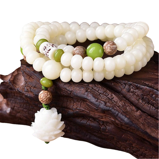 Intricate white beads and green accents on a wooden surface