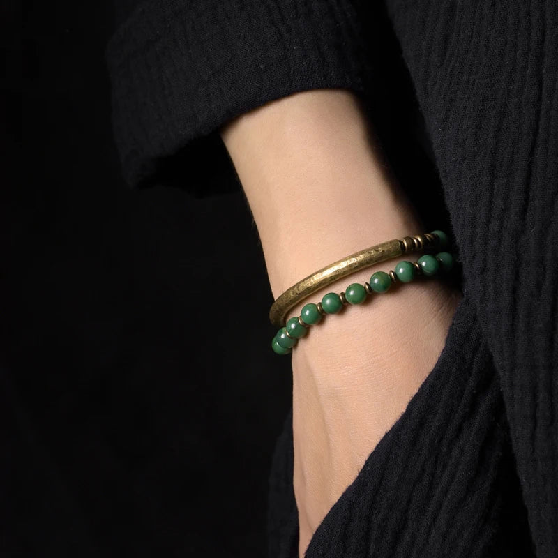 Minimalist copper cuff adorned with calming African Grass Jade stones to promote wisdom