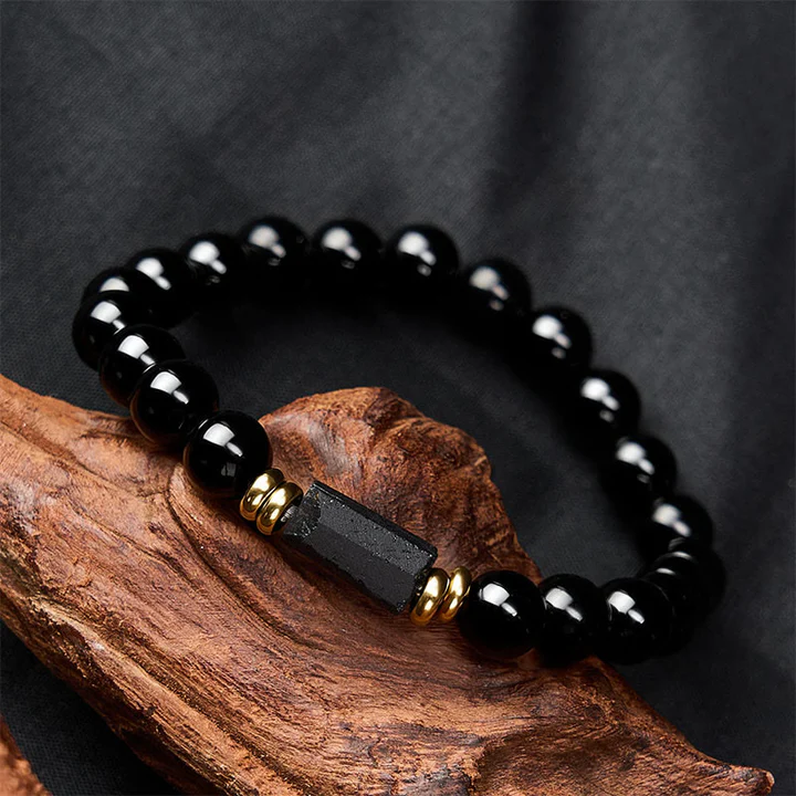 Minimalist black tourmaline EMF protection bracelet with gold accents and natural stone texture