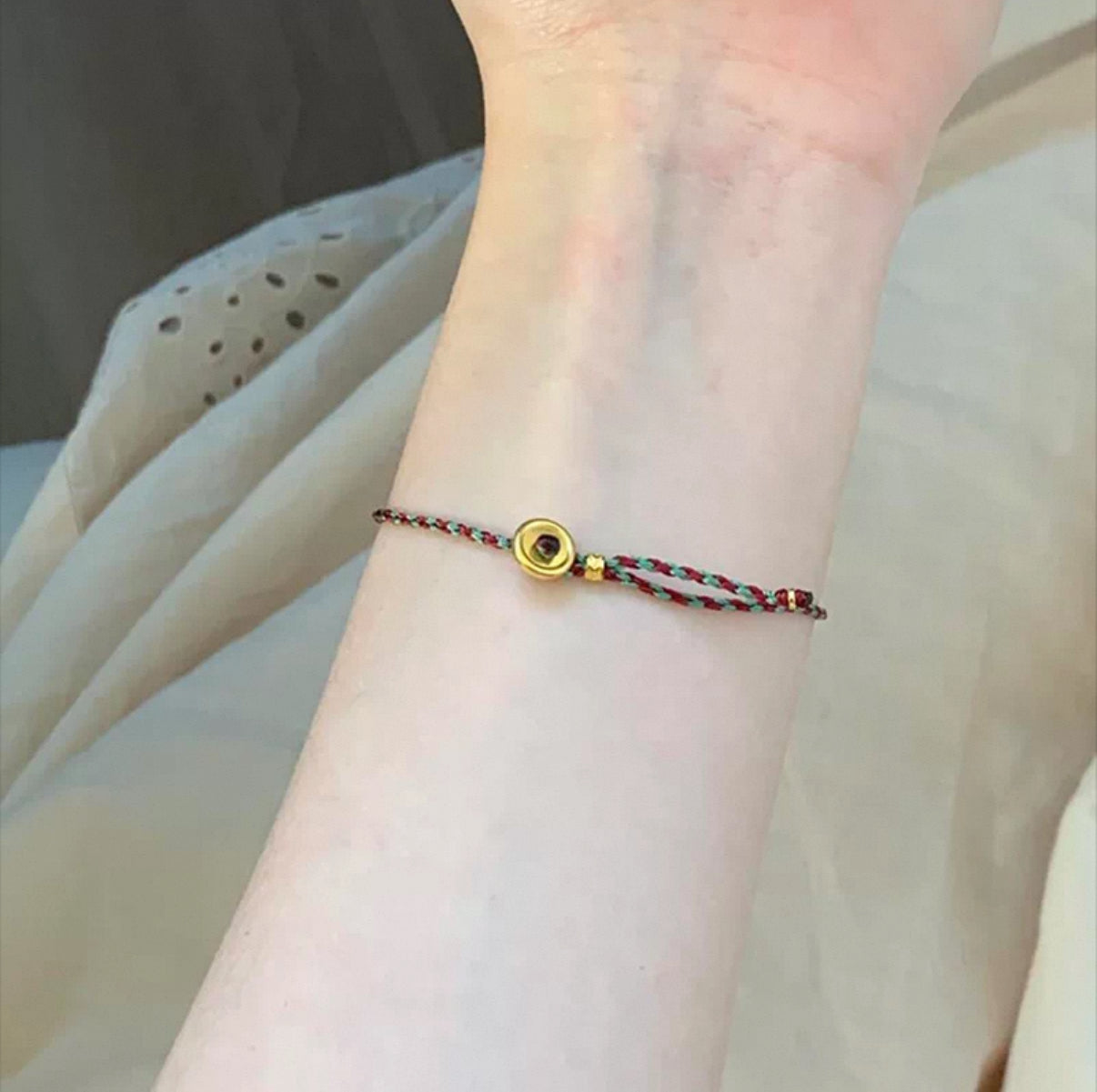 Close-up showing adjustable sliding knot of braided gourd bracelet