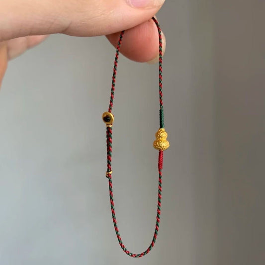 Handmade gourd charm bracelet with gold-plated finish on red and green braided cord