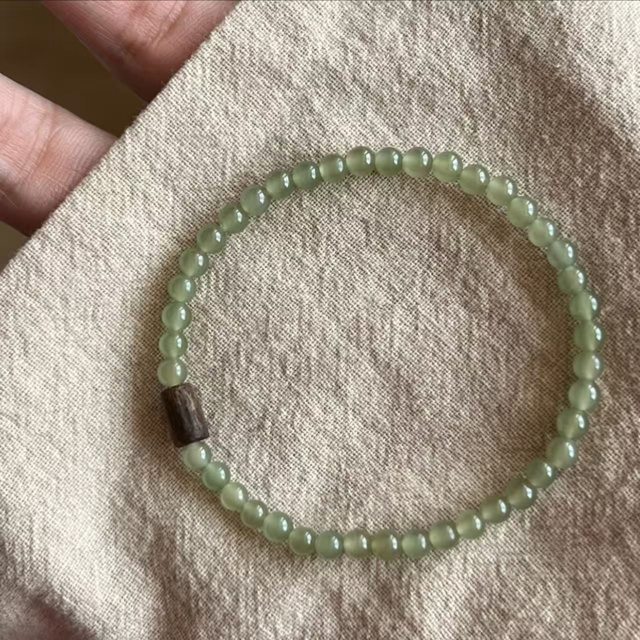 Close-up of smooth nephrite jade bead detail with pale green tone