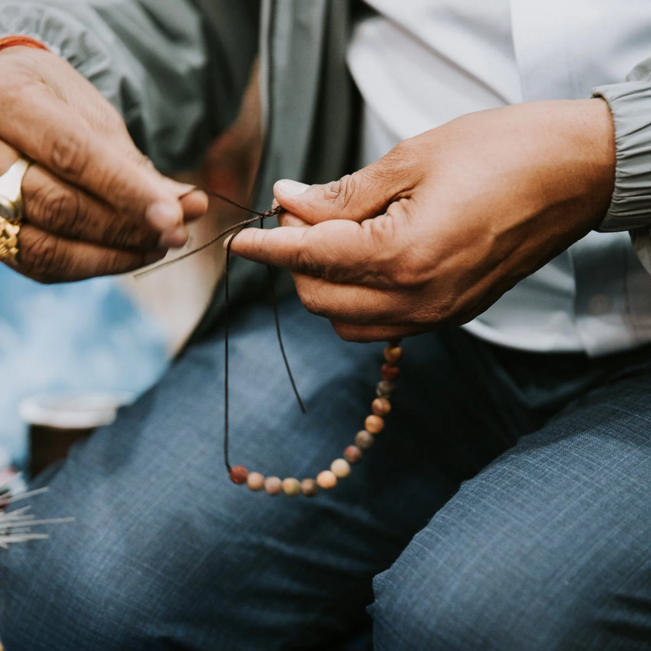 The craftsman threadind the mala bead bracelet