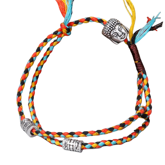 Intricate, colorful braided bracelet with decorative Buddha head charm against a dark background