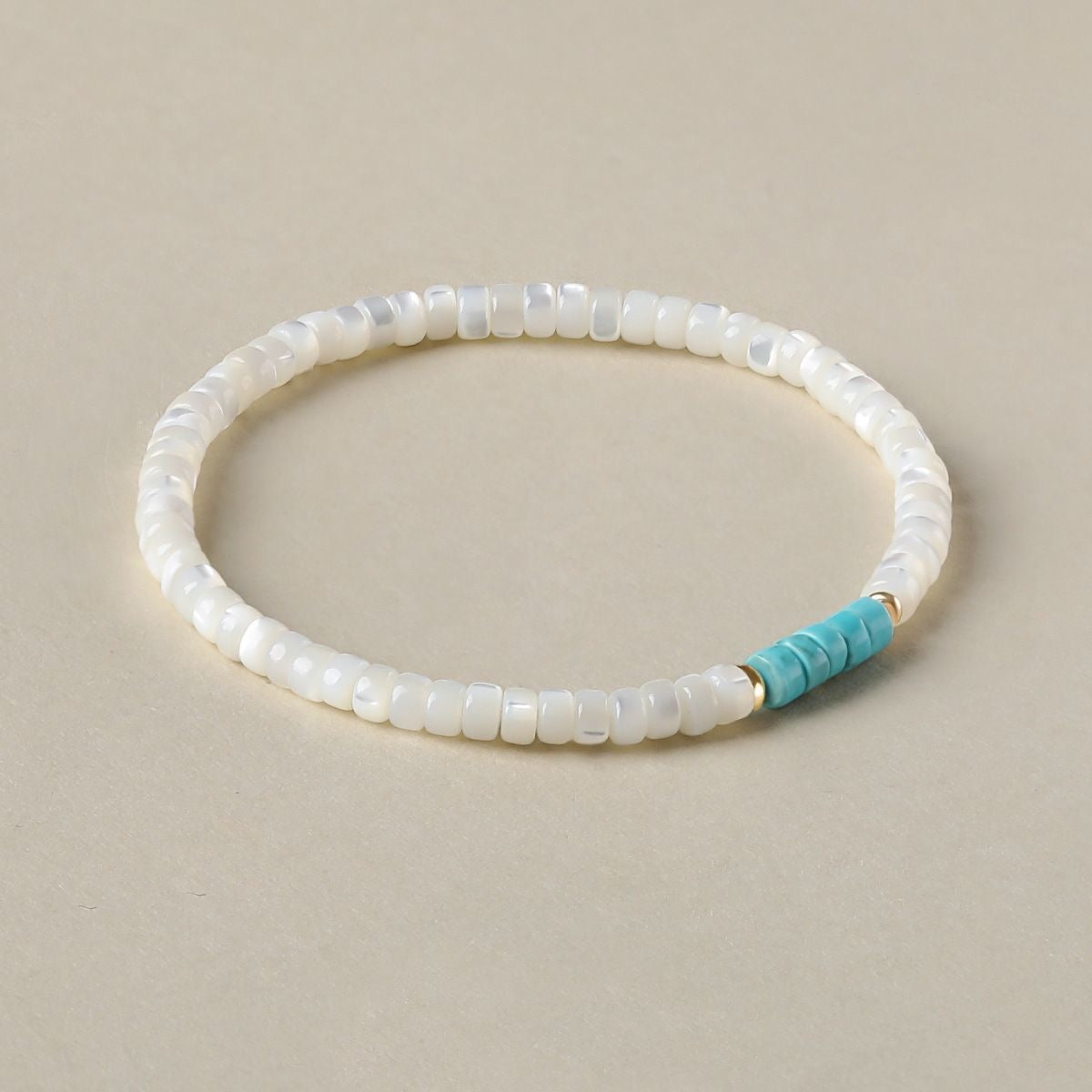 Heishi shell bracelet featuring turquoise spacer at center
