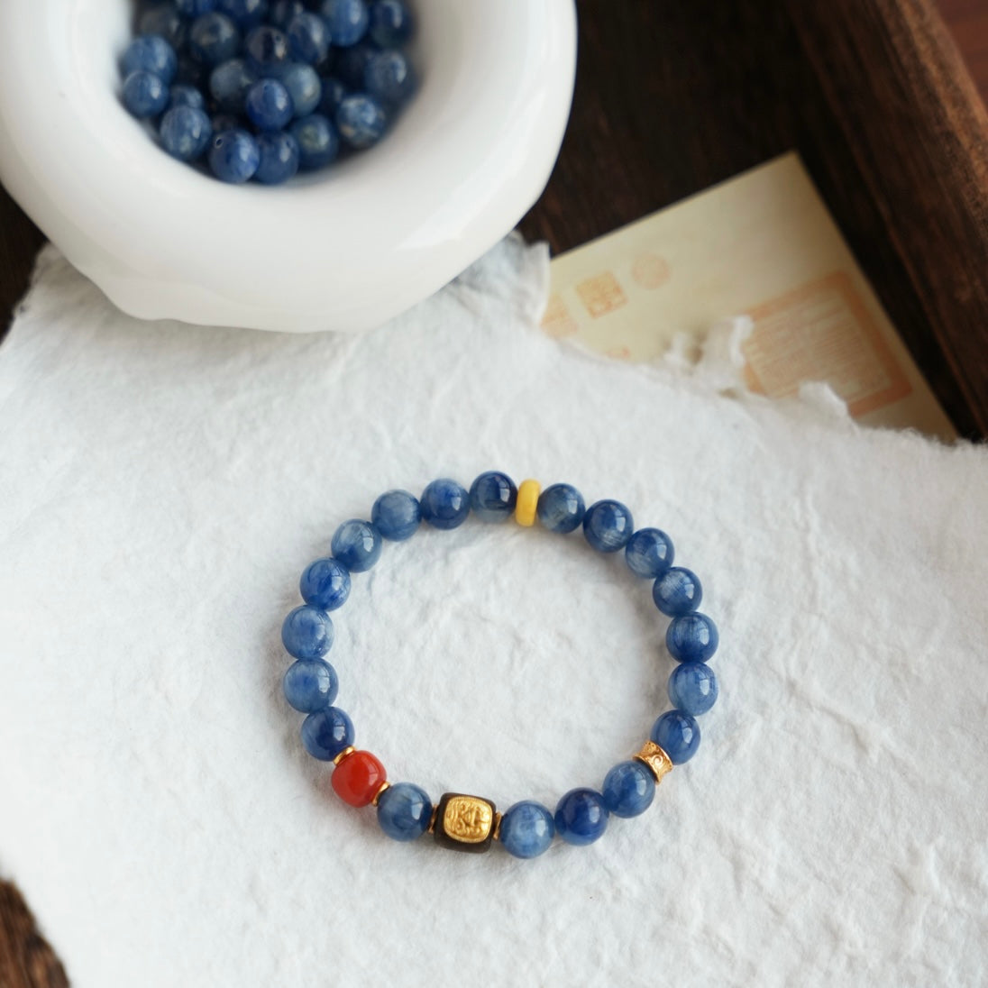 Handmade bracelet featuring natural kyanite, red agate beads, and agarwood charm.