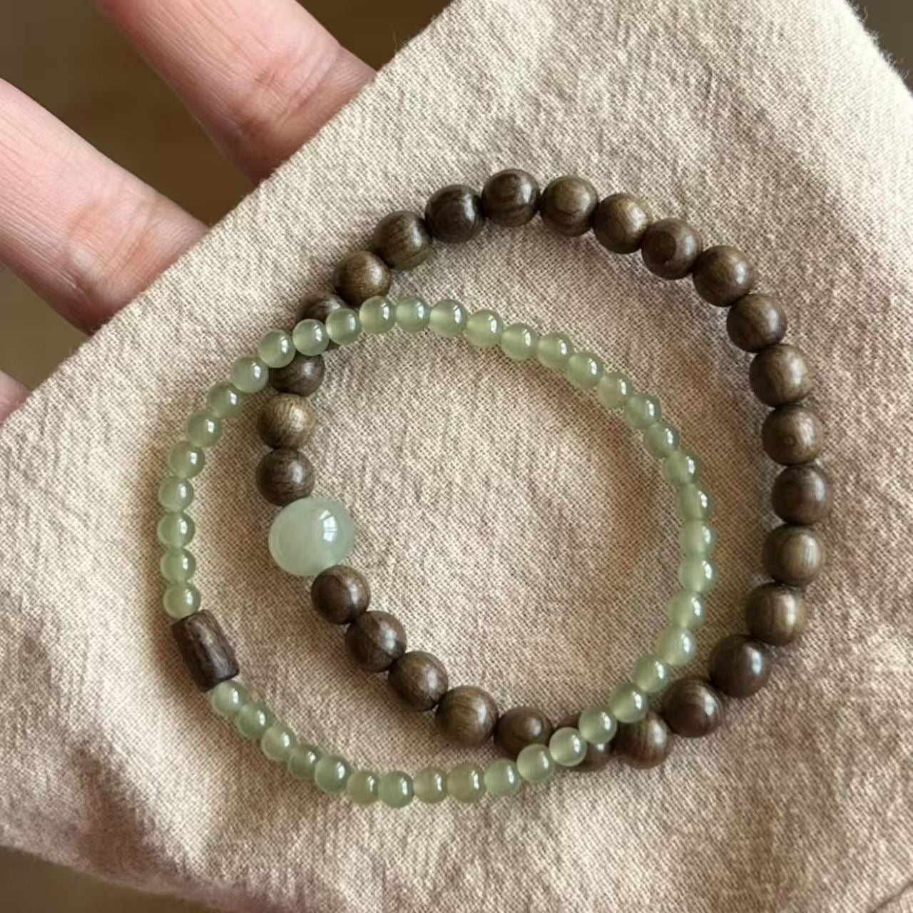Flat lay of sandalwood and nephrite jade stack bracelet set