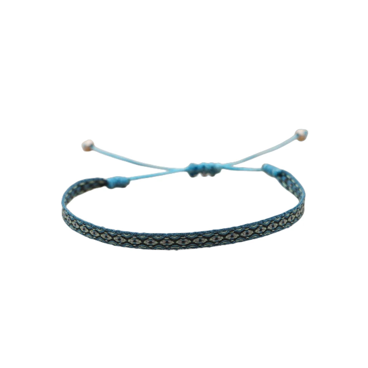 Seville flat woven boho bracelet — tight small-loom cotton weave, low-profile band that layers neatly between cuff and rope