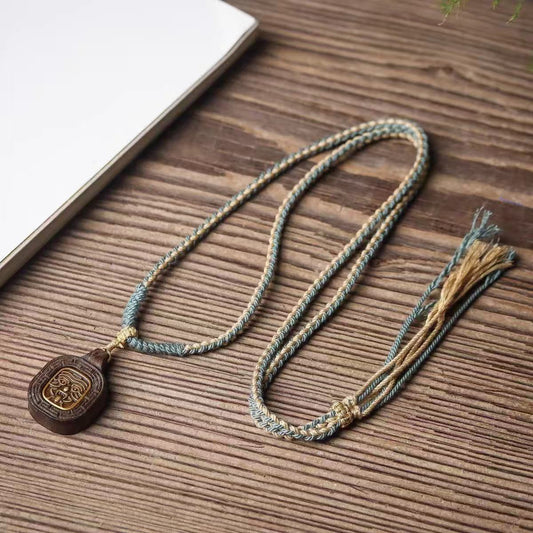 Full view of Tibetan Zashi Lhamo wood-carved amulet necklace, adjustable cord