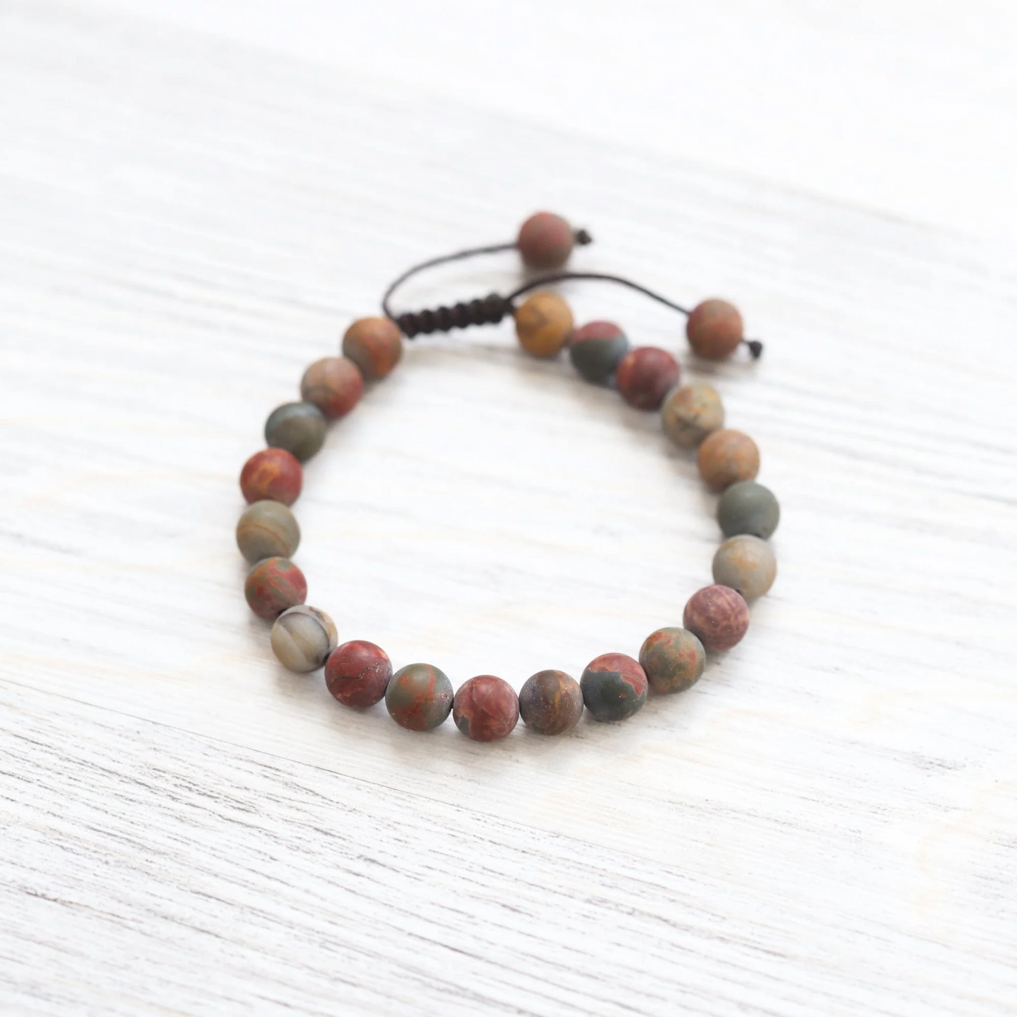 Tibetan artisan handcrafting riverstone mala bracelet