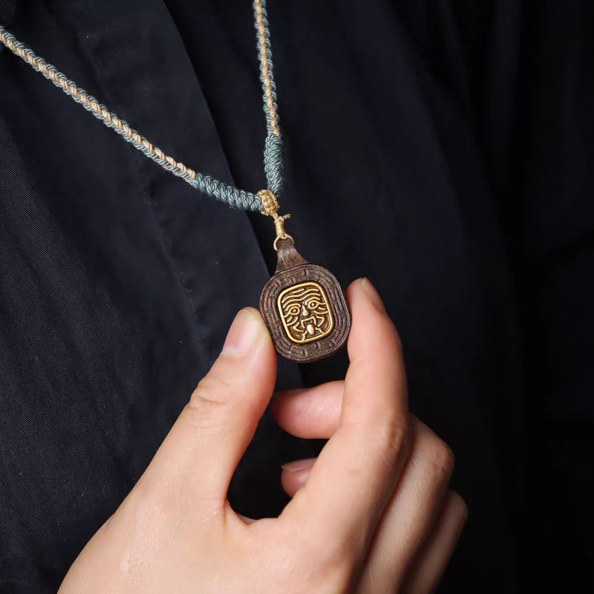 Lifestyle flat lay of Tibetan Zashi Lhamo wood-carved pendant with Tibetan knot